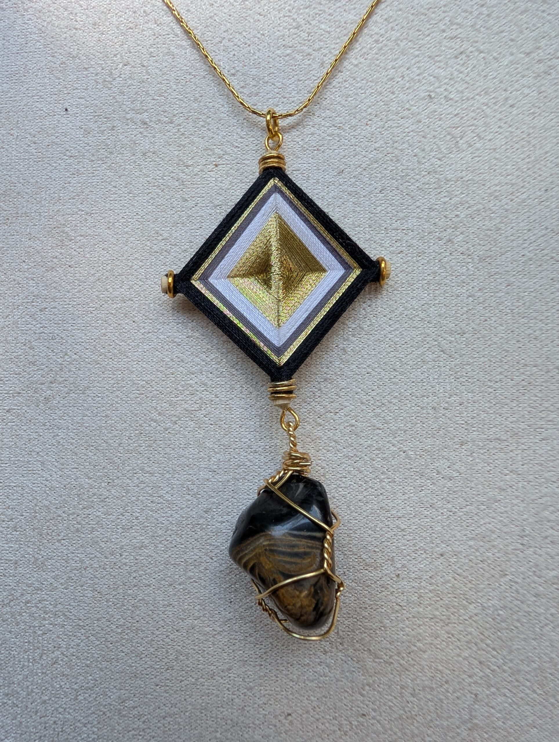 Pendentif noir artisanal élaboré en pierre naturelle et œil de Dieu. Fabrication artisanale au Mexique
